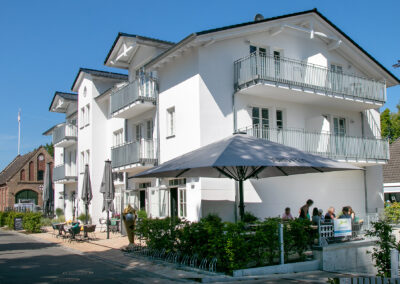 großes, weißes Haus mit Balkonen, Wohn- u. Geschäftshaus, Referenz Baubetrieb Ostseeland Bau GmbH