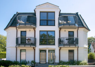 weiße Villa mit Balkonen, Referenz für Rohbauarbeiten durch Baubetrieb Ostseeland Bau GmbH